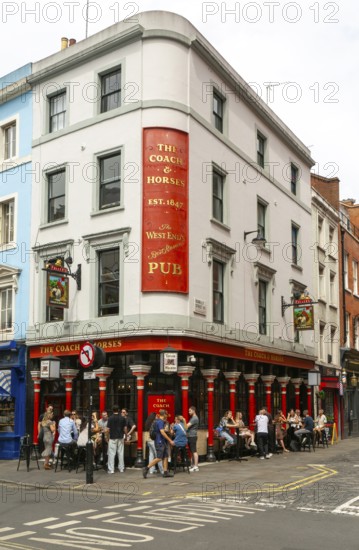 People sitting outside The Coach and Horses pub, Romilly Street, Soho, London, England, UK