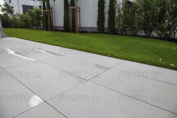 Modern terrace with large, light-coloured terrace tiles on a new detached house