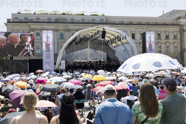 Audience with sun protection at the Staatsoper für alle, a free open-air concert with conductor Christian Thielemann and the Staatskapelle Berlin on Berlin's Bebelplatz, Berlin, 22 June 2025