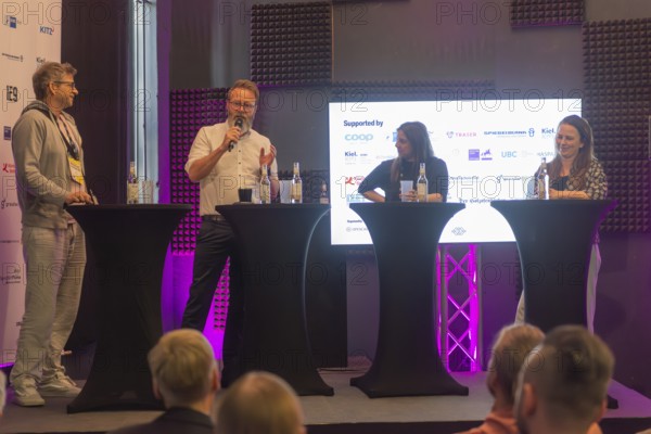 Waterkant Festival 25 in front of Kiel Week 2025 at the MGF 5 site on the Kiel Fjord, annual meeting place for founders of start-up companies with innovative ideas for new technologies, ecology and society, workshops and exhibitions, discussion with Claus Ruhe Madsen, Schleswig-Holstein's Minister for Economic Affairs, Transport, Labour, Technology and Tourism (with micro), Kiel Holtenau, Schleswig-Holstein, Germany