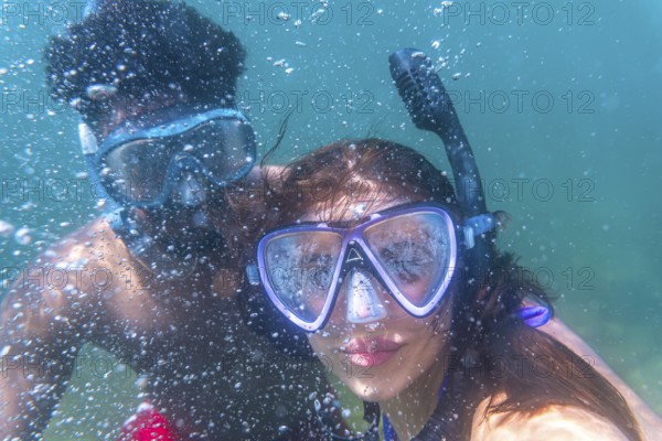 Young couple exploring the underwater world, enjoying their snorkeling adventure in crystal clear turquoise water