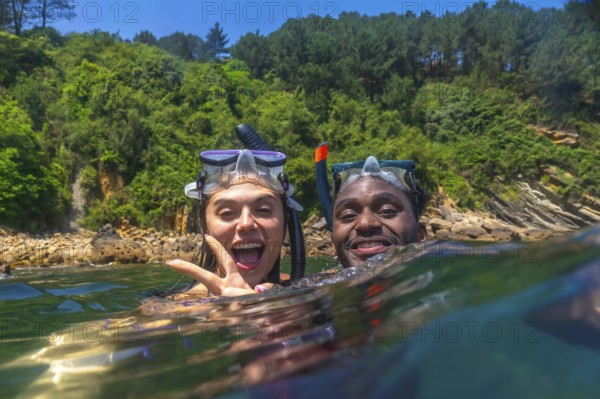 Interracial couple snorkeling together in the vibrant ocean, enjoying a fun filled summer vacation and creating joyful memories