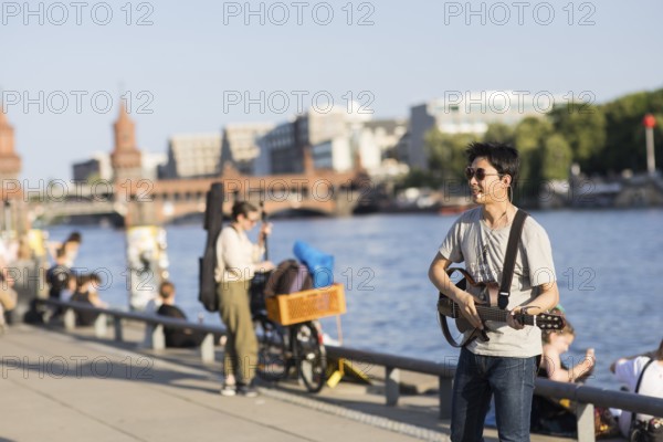 Guitarist at the East Side Gallery in front of the Spree as part of the Fête de la Musique. The music event, which originated in France, has been held as a street event on the longest day of the year on 21 June since 1982. The Fête de la Musique has also been held in Berlin since 1995 and is celebrating its 30th anniversary this year. 21.06.2025