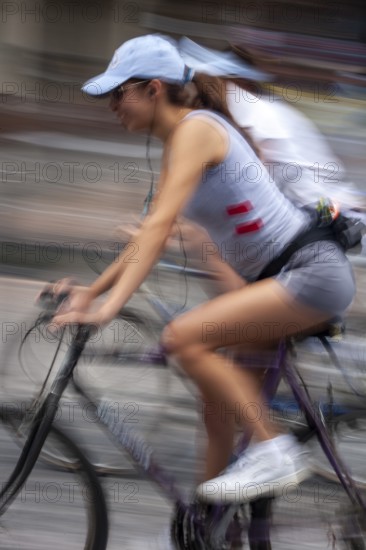 Women riding on bicycles, Photo with motion blur, City of Quito, Pichincha province, Ecuador, South America