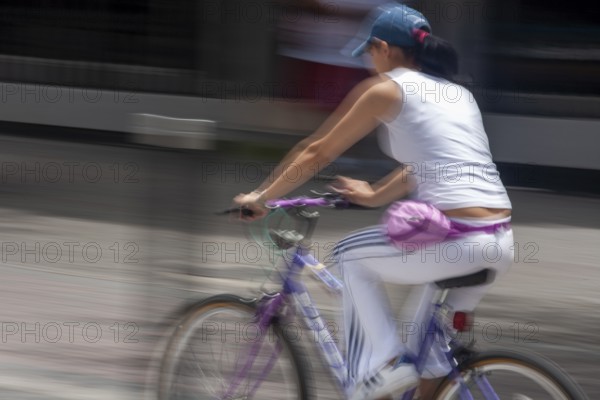 Woman riding a bicycle, Photo with motion blur, City of Quito, Pichincha province, Ecuador, South America