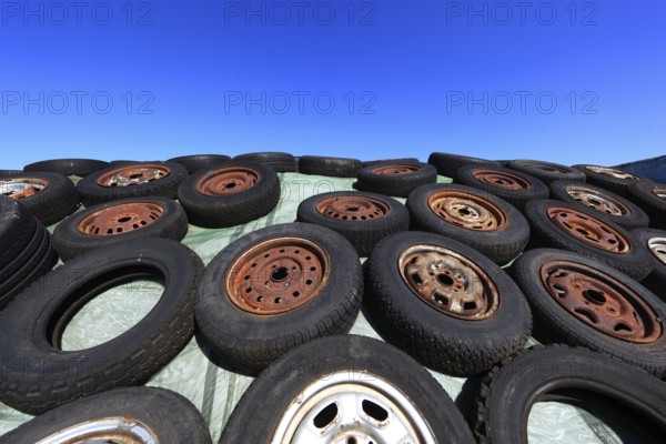 Old wheels, rims and tyres, used here to weigh down the cover of an agricultural silo