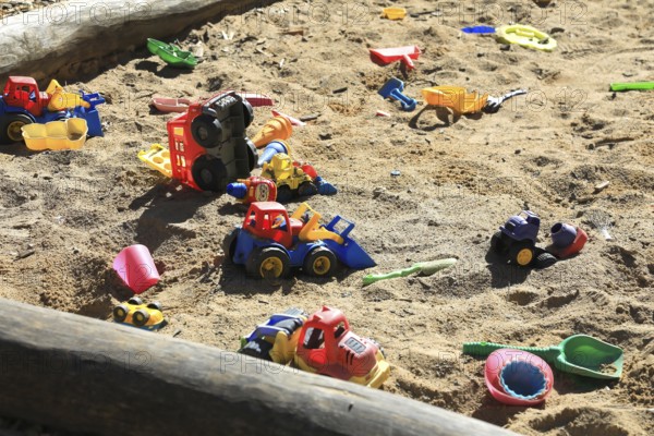Playground, sandpit with plastic toys, vehicles, shovel