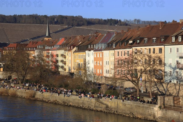 People enjoying the first spring sunshine along the old town houses on the Main, Würzburg, Lower Franconia, Bavaria, Germany