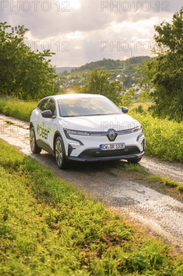Car on a rural road surrounded by trees and a wide landscape, Deer E- CarSharing, Renault Megane electric car, Calw, Black Forest, Germany