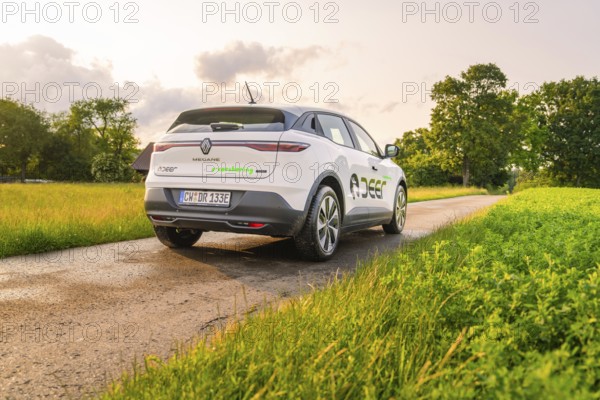 Renault on a country road, surrounded by lush green meadows and trees, Deer E- CarSharing, Renault Megane electric car, Calw, Black Forest, Germany