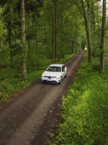 Car on a green forest path, surrounded by dense forest, Deer E- CarSharing, Renault Megane electric car, Calw, Black Forest, Germany