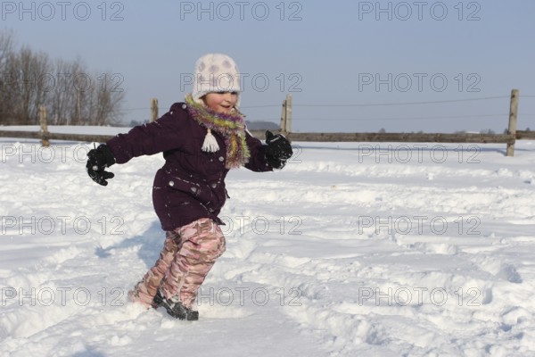 Girl running in the snow, Allgäu, Bavaria, Germany, Allgäu, Bavaria, Germany