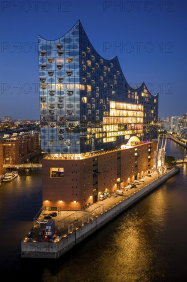 Aerial view of the Elbphilharmonie at blue hour with illuminated windows and view over the Speicherstadt and Hafencity, Hamburg, Germany