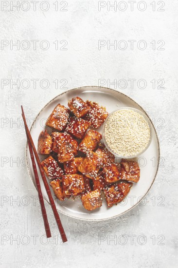 Fried pieces of salmon teriyaki with sesame seeds, top view