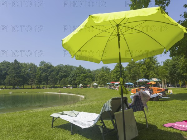 Sunshades and sunbeds by a lake