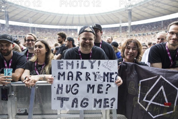 A fan holds a poster with the words Emily! Marry me? Hug me? Tag me? (Emily! Marry me? Hug me? Link me?) at Linkin Park live on From Zero World Tour 2025 at the Olympiastadion Berlin on 18.06.2025