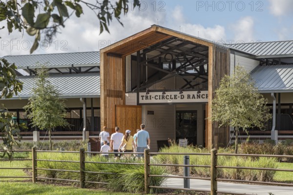 Family entering the Tri-Circle-D Ranch horse stables in the Fort Wilderness Campground and Resort at Disney World in Orlando, Florida