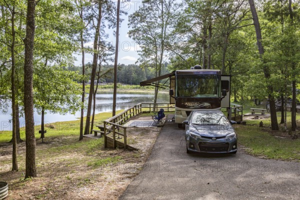 Motorhome parked in a campsite on the bank of the lake at Little Black Creek campground near Lumberton, Mississippi