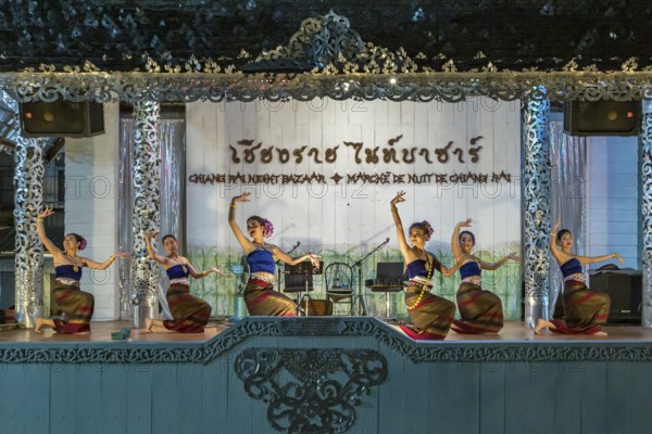 Traditional Thai dancers perform on a lighted stage at the night market in downtown Chiang Rai, Thailand