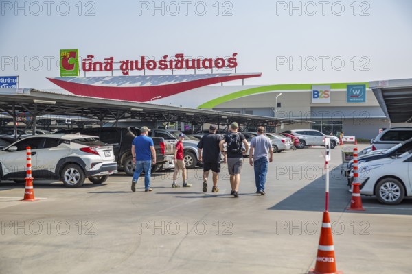 American men walking in parking lot towards the Big C Supercenter in Chiang Rai, Thailand