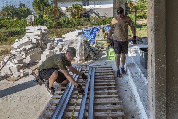 American men preparing metal studs while volunteering to help build the Grace Language School and Baan Athitaan Church building in Chiang Rai, Thailand