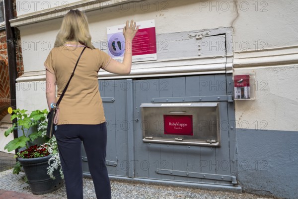Woman waving in front of baby hatch