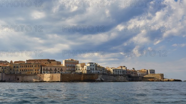 City along the coast with high clouds on the horizon, boat trip around the island of Ortigia, Isola di Ortigia, Syracuse, Sicily, Italy