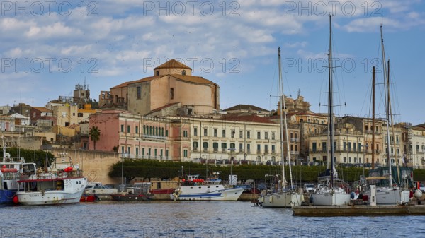 Harbour view with yachts and old buildings under a slightly cloudy sky, boat trip around the island of Ortigia, Isola di Ortigia, Syracuse, Sicily, Italy
