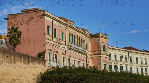 Pink historic building with many windows under a blue sky, Ortigia Island, Isola di Ortigia, Historic Centre, Syracuse, Sicily, Italy