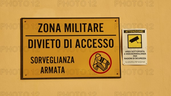 Warning sign on a wall indicating a military zone with restricted access and surveillance, Ortigia Island, Isola di Ortigia, Historic Centre, Syracuse, Sicily, Italy