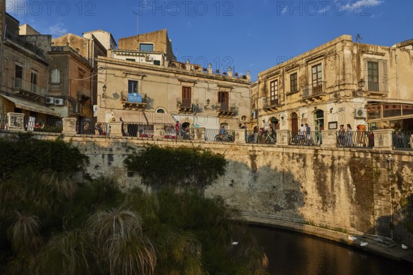 Largo Aretusa, Fonte Aretusa, View of a busy bridge and old buildings under a blue sky, Ortigia Island, Isola di Ortigia, Historic old town, Syracuse, Sicily, Italy