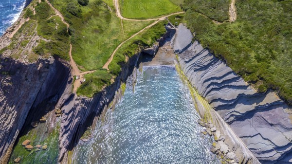 Aerial view of the impressive flysch cliffs of zumaia, basque country, spain, meeting the cantabrian sea during a sunny summer day, Spain.