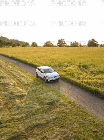Electric car driving on a lonely country road between wide grain fields in the sunset, Renault Megane, Deer E Carsharing, electric car, Calw, Black Forest, Germany
