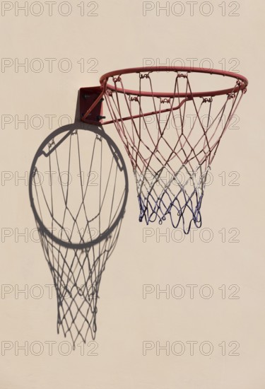 Basketball hoop with shadow cast on a white wall