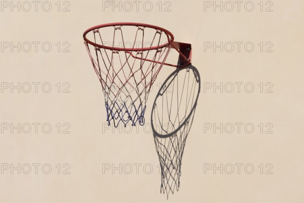 Basketball hoop with shadow cast on a white wall
