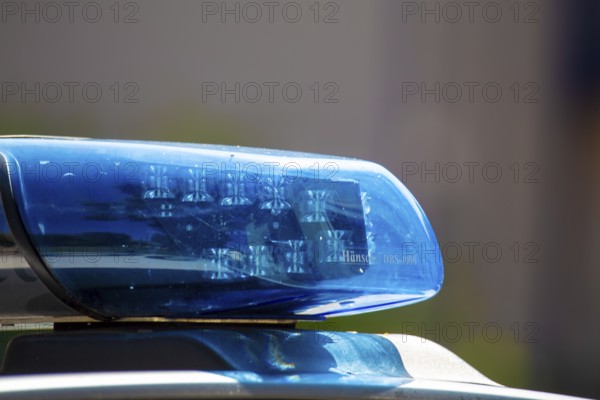 Symbolic image of a police operation: close-up of a flashing blue light on a police car