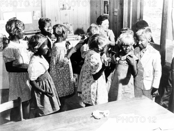 Children made up black face, 1920s, A group of children in a room, apparently for a class reunion or event, Historical photo