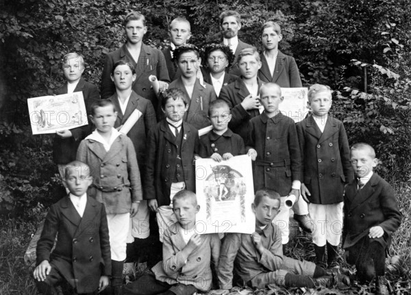Young sports group with their awards, 1920s, boys in fine clothes, some with certificates, posing in the forest, historical photo