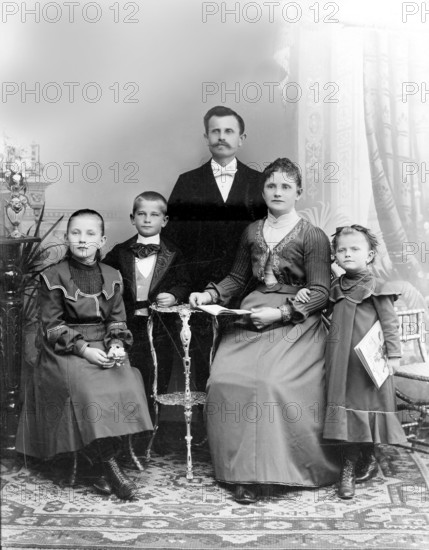 Father Mother Boy Girl, 1920s, A formal family portrait with parents and three children in traditional dress, Historical photograph
