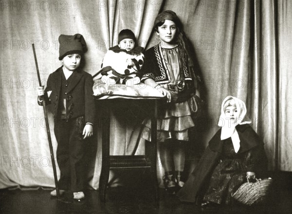 Children dressed up, 1910s, Four children in traditional costumes in front of a curtain, Group portrait in nostalgic style, Historical photo