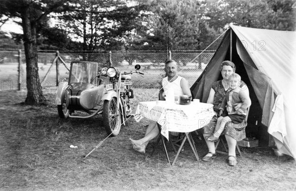 Camping family, 1930s, family camping next to a tent and motorbike, relaxed outdoor atmosphere, historical photo