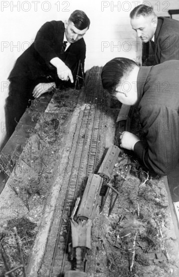 Men playing with a railway 1940, Men working concentrated on a model railway layout, historical photo