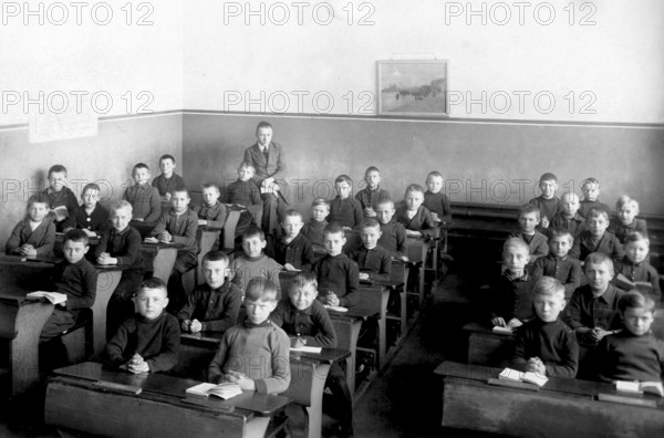 School class, all boys, 1920s, Young schoolboys sitting in a classroom with textbooks and writing, Historical photo