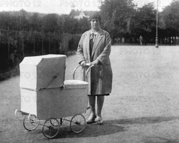 Woman with pram, 1930s, Woman with pram in a park, historical black and white photo with vintage atmosphere, Historical photo