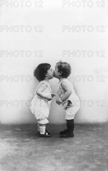 Two little children kissing, 1920s, Two little children giving each other a kiss while looking at each other lovingly, Historical photo