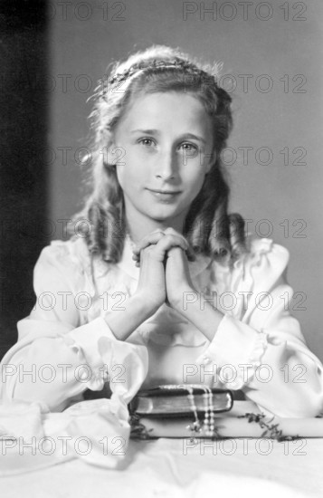 Praying girl, 1930s, A young girl in nostalgic clothing, dreamy and elegant, looks at the viewer, Historical photo