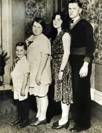 Family photo set up according to size, 1920s, Four people posing standing for a family portrait, Historical photo