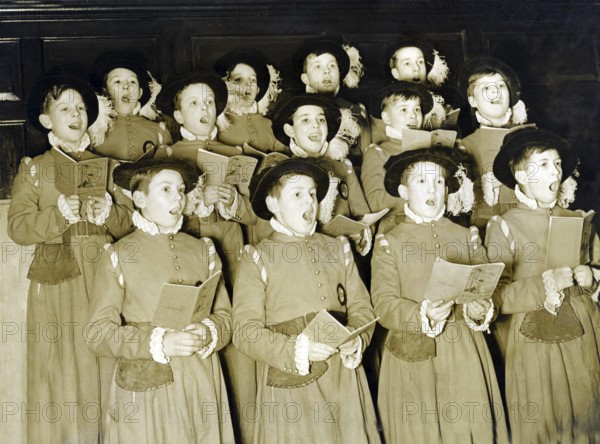 Traditional boys' choir, 1930s, group of children in historical costumes singing together in a choir. The scene appears harmonious and solemn, historical photo
