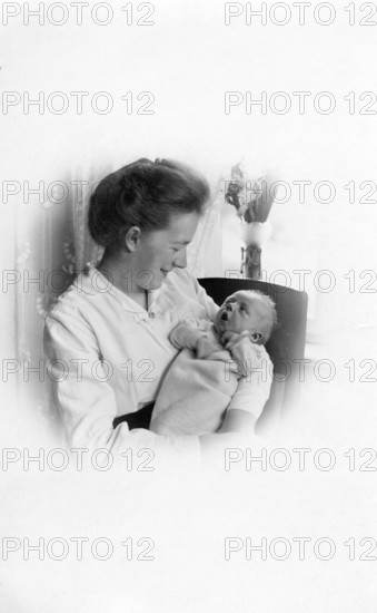 Woman with baby in her arms, 1930s, A woman lovingly holds a baby in her arms, Historical photo