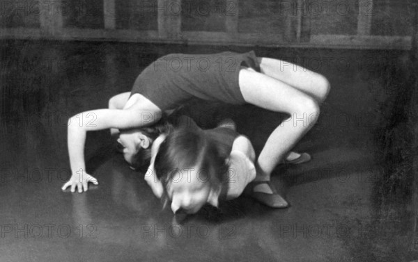 Children practising acrobatics, 1920s, Two children performing a gymnastic exercise on a floor, historical photo